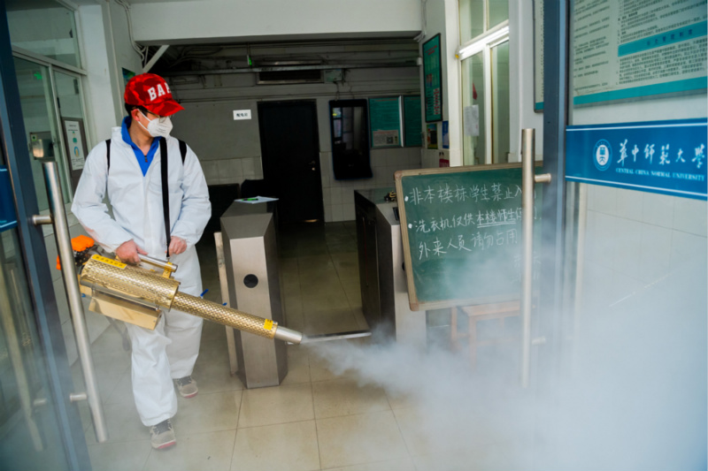 在华中师范大学学生宿舍区域内，工作人员进行全面消杀。陈希昌/摄