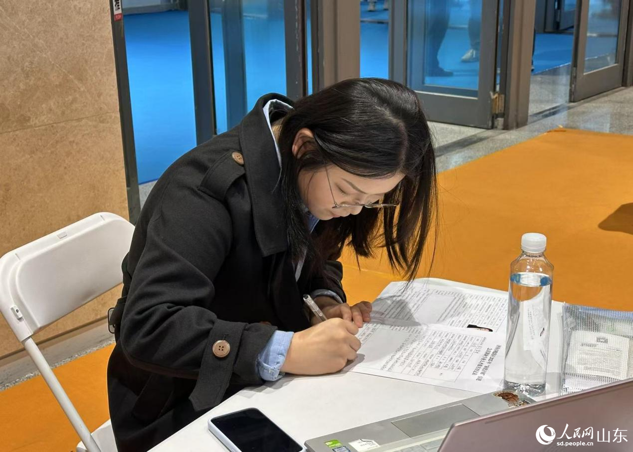 求职者达成就职意向，现场填写岗位登记表。人民网 乔姝摄